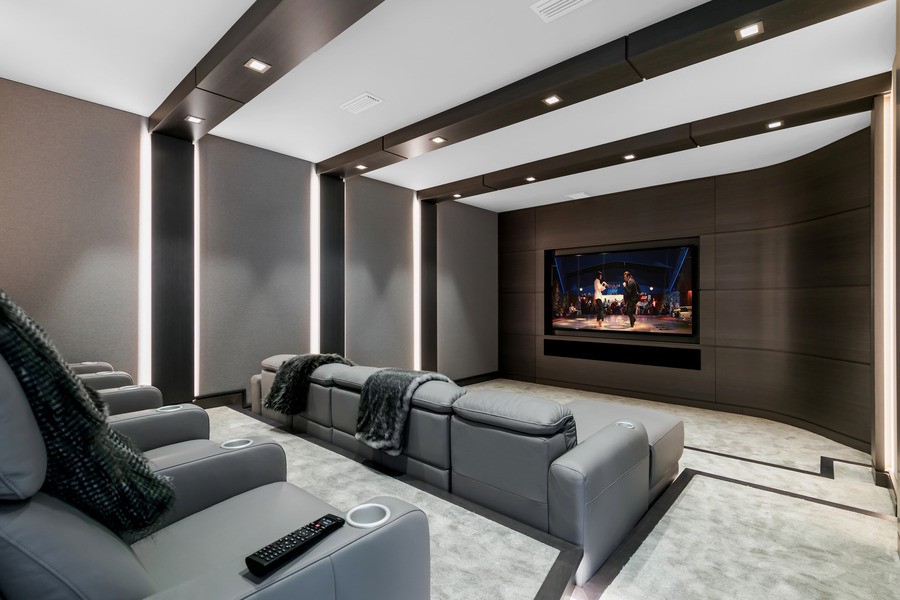 A luxurious home theater with a movie still on the screen.
