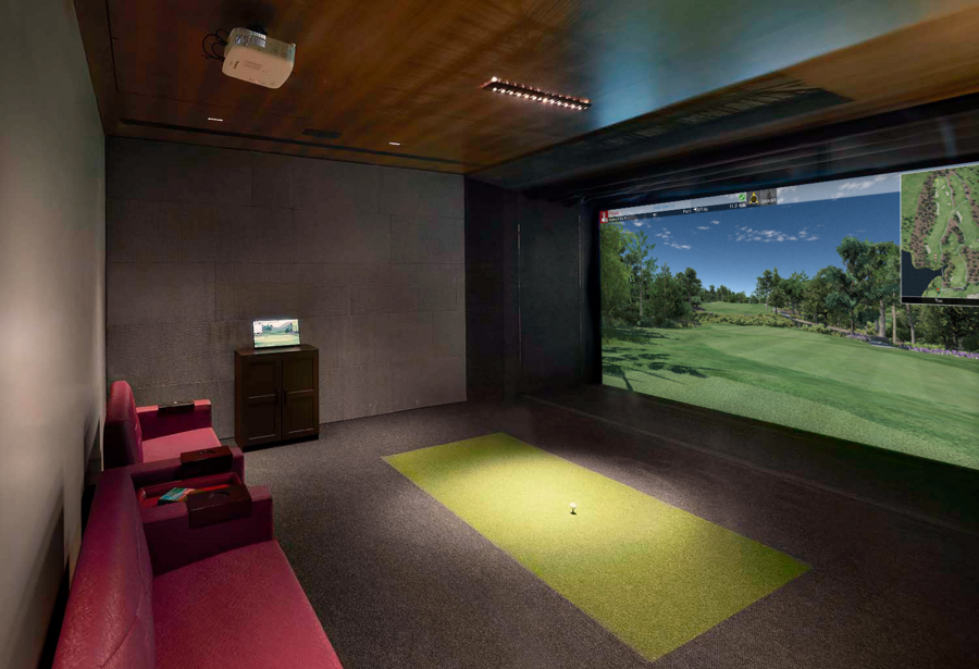 A modern home theater with a golf simulation setup.